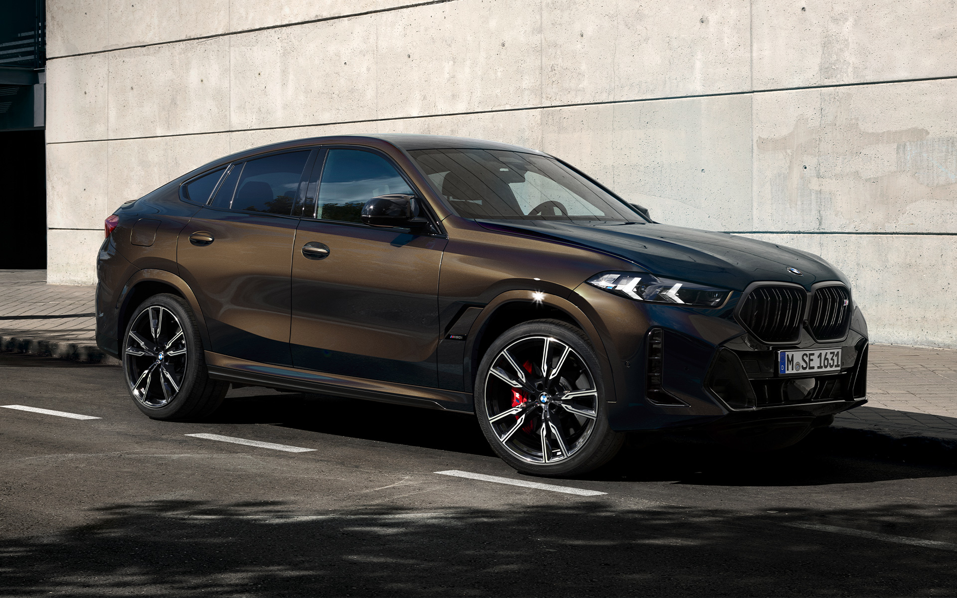 BMW X6 M60i G06 in BMW Individual Pyrite Brown metallic, 2/3 side view, parking in parking lot